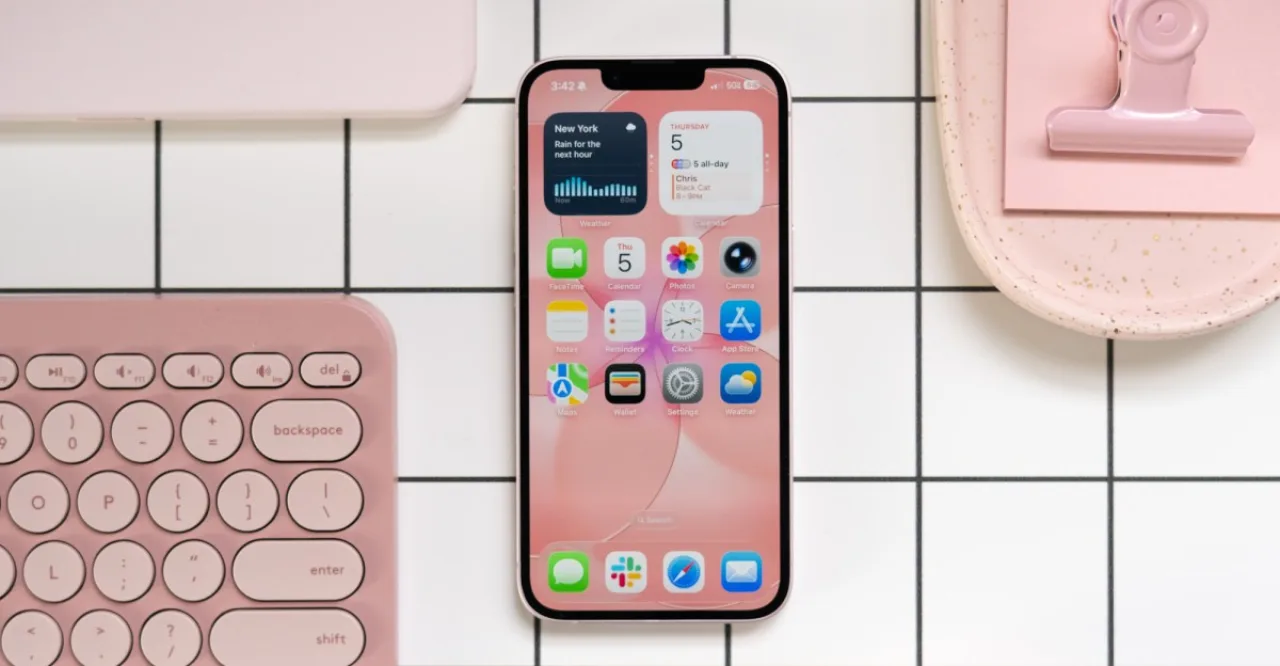 Pessoa correndo ao ar livre, segurando iPhone desbloqueado, com fones de ouvido e garrafa de água ao lado