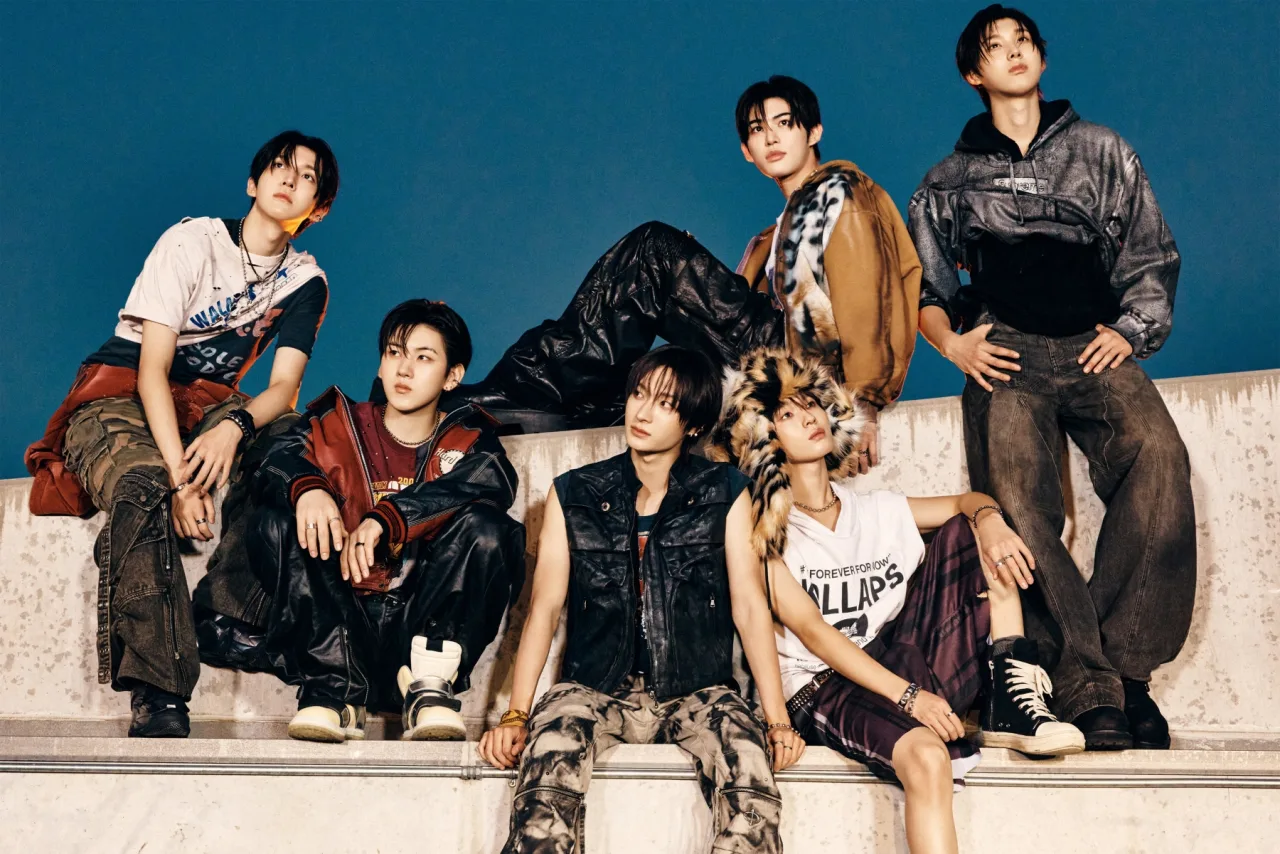 Membros do KickFlip posam em trajes neon ao lado do mini‑álbum ‘KICK OFF THE WALL Pt. 1’ e do logo da JYP