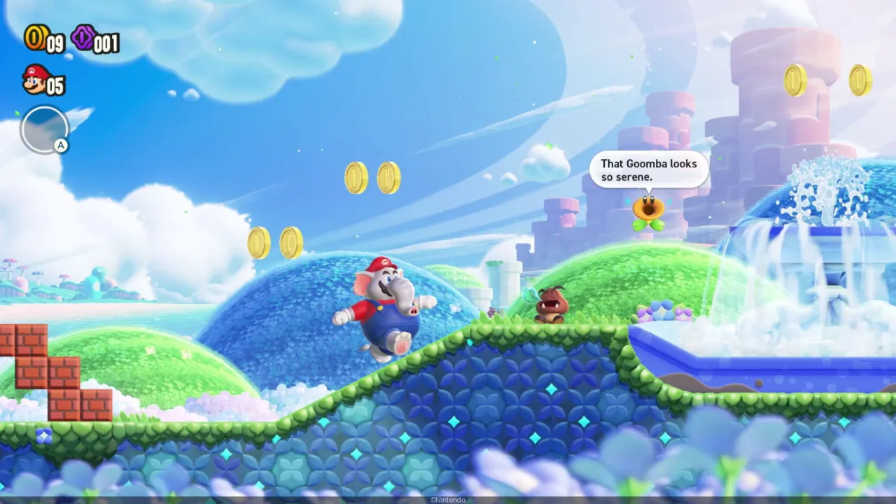 Elephant Mario em miniatura, com tromba e bigode, posado sobre base preta ao lado da caixa da First 4 Figures