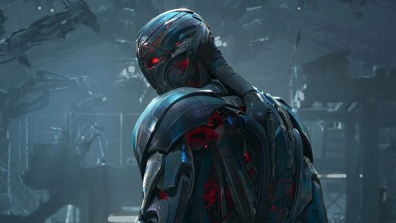 Um atleta vestindo camiseta da Marvel levanta halteres enquanto ao fundo aparecem pôsteres de “Avengers: Age of Ultron”