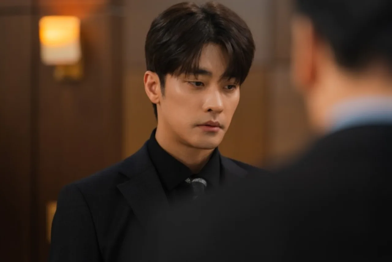 Sung Hoon, de terno escuro, posa ao lado do logo “What a Boss Wants” em fundo neutro