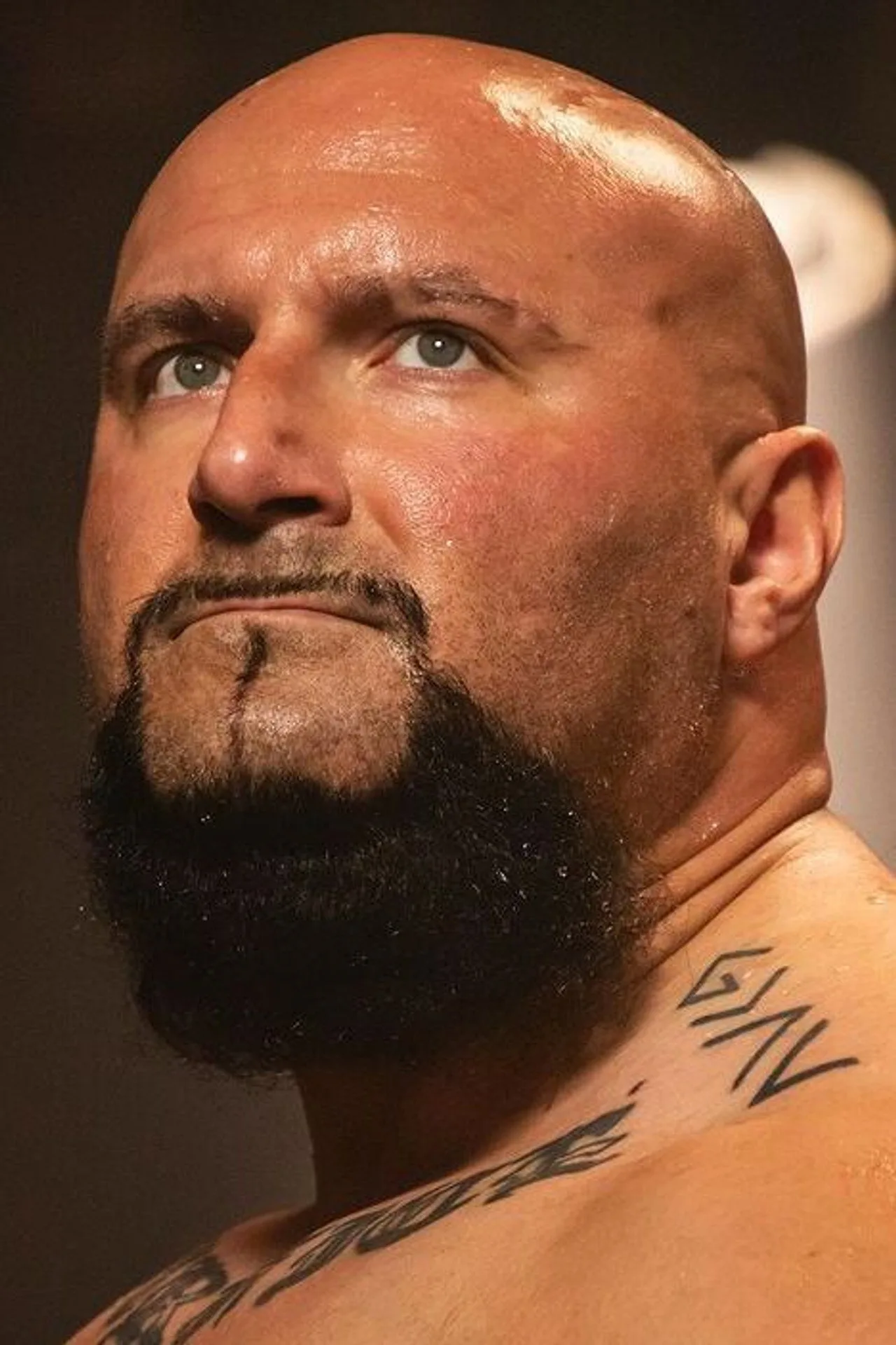 Bautista faz supino com barra enquanto veste camiseta de Kratos, ao lado de halteres e garrafa de água