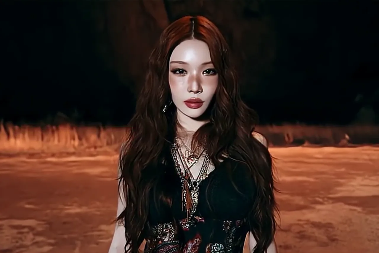 Chungha vestindo roupa esportiva vibrante, segurando garrafa d'água ao lado de um tapete de yoga com bandeira mexicana