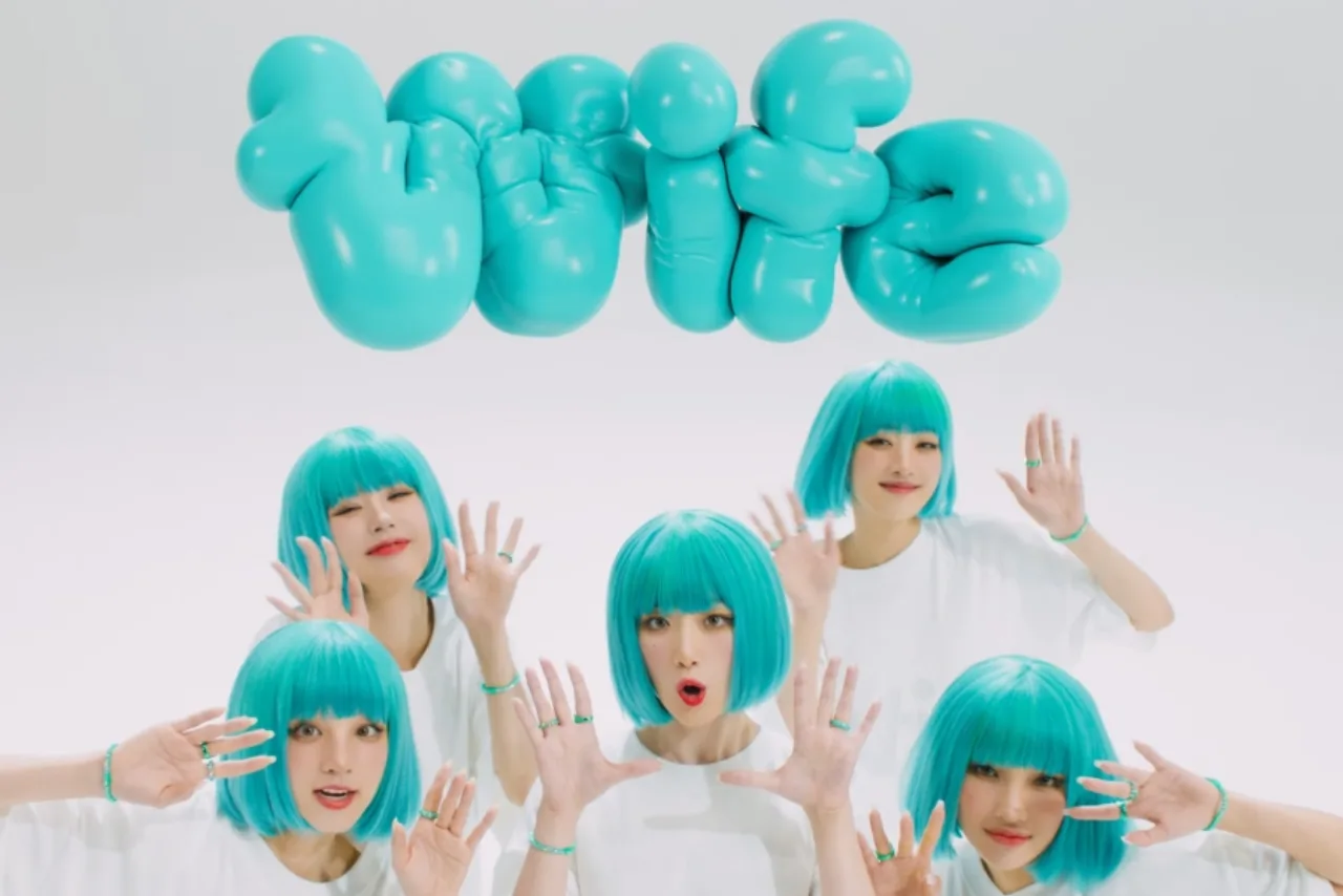 Membros da i-dle posam em traje futurista, com o título “Wife” projetado ao fundo em neon