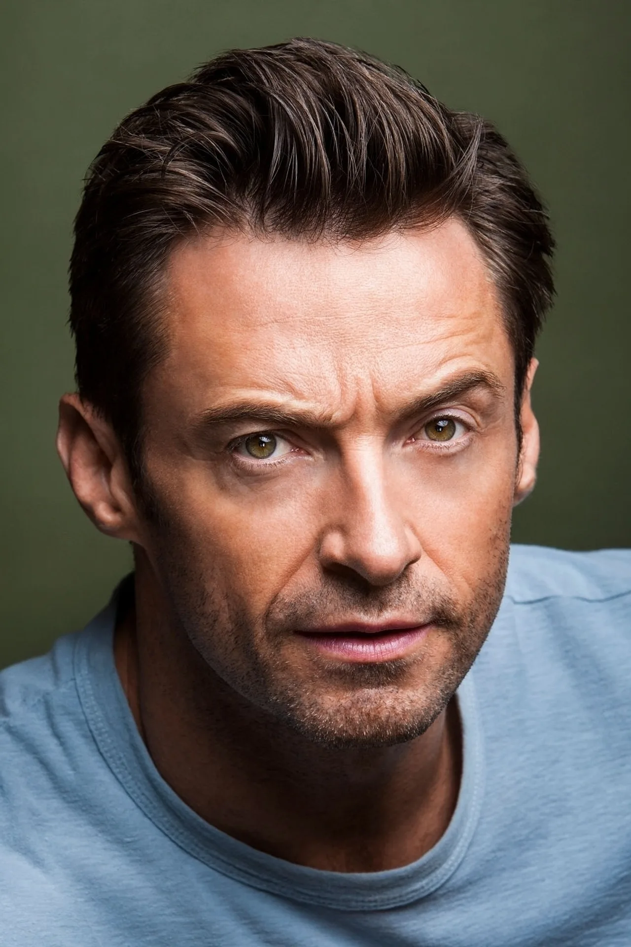 Hugh Jackman vestindo roupa de treino, segurando halteres e fazendo agachamento em academia