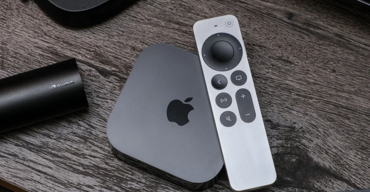 Apple TV ao lado de um controle Siri com alto-falante e ícone de microfone, sobre fundo branco