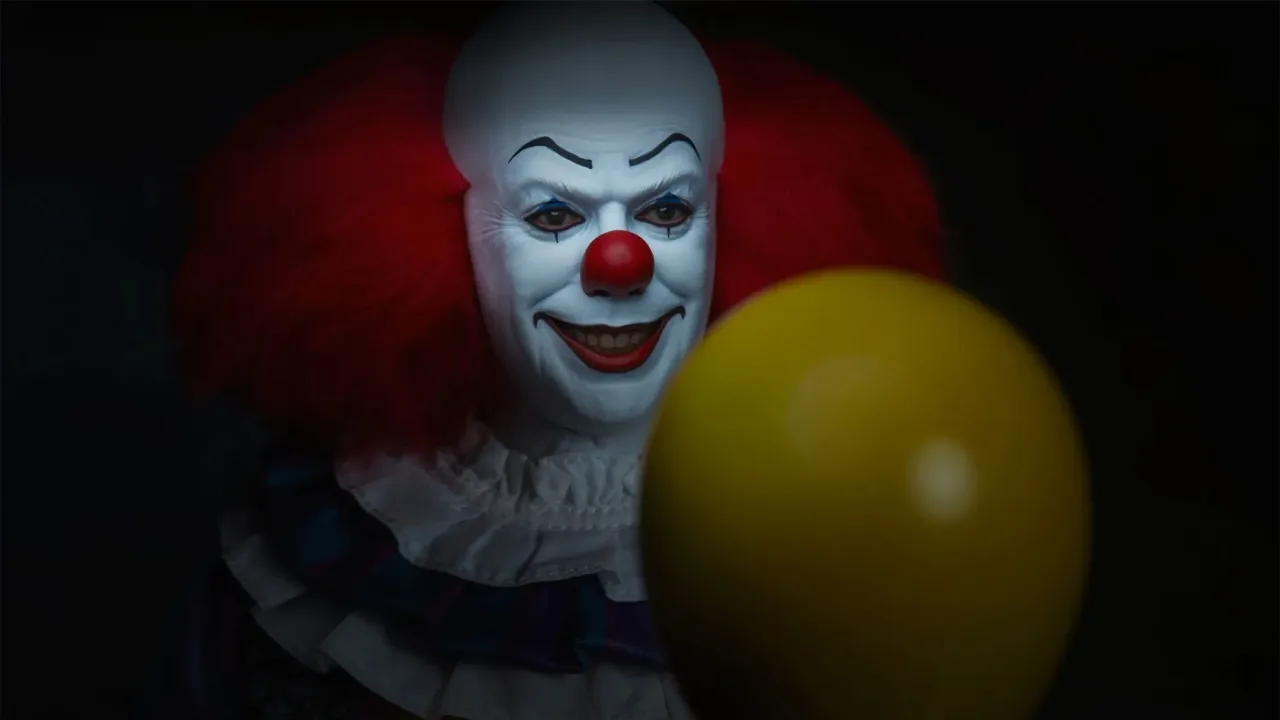 Figura de Pennywise da Sideshow com duas cabeças, mãos demoníacas e balão amarelo, no traje icônico de Tim Curry