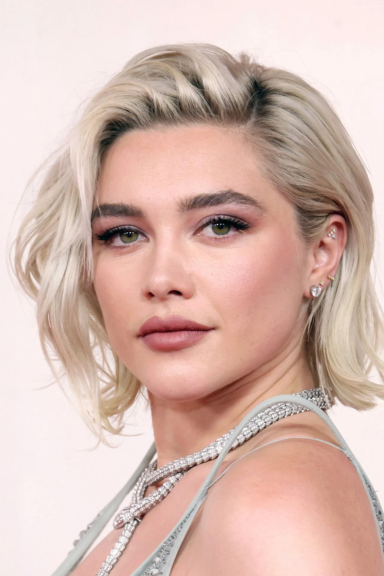 Florence Pugh como Yelena Belova ao lado de Spider‑Man, ambos em ação, com luzes neon e painéis de tecnologia ao fundo