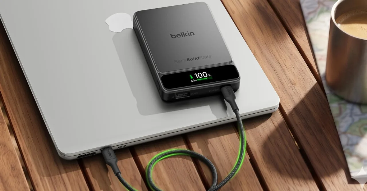 Jovem correndo ao ar livre, segurando smartphone e power bank Belkin semi‑solid preso ao cinto
