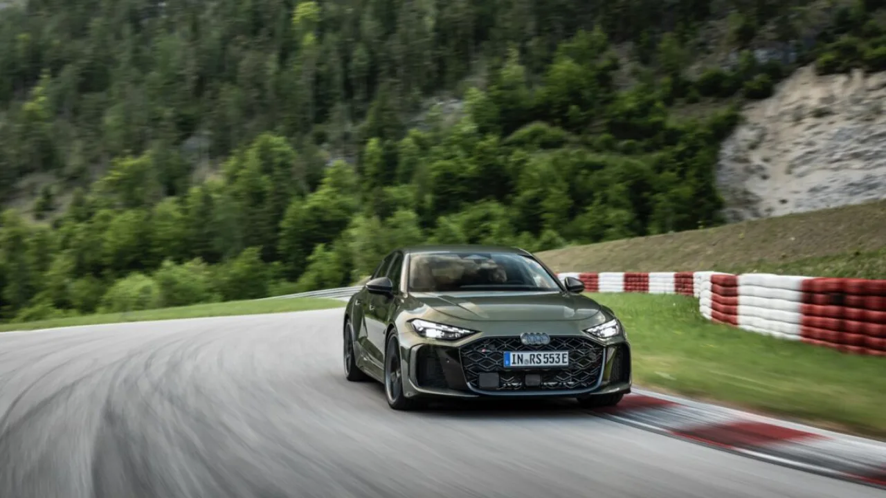 Homem atlético em roupas esportivas ajustando um cabo de carregamento elétrico ao lado de um Audi RS5 moderno