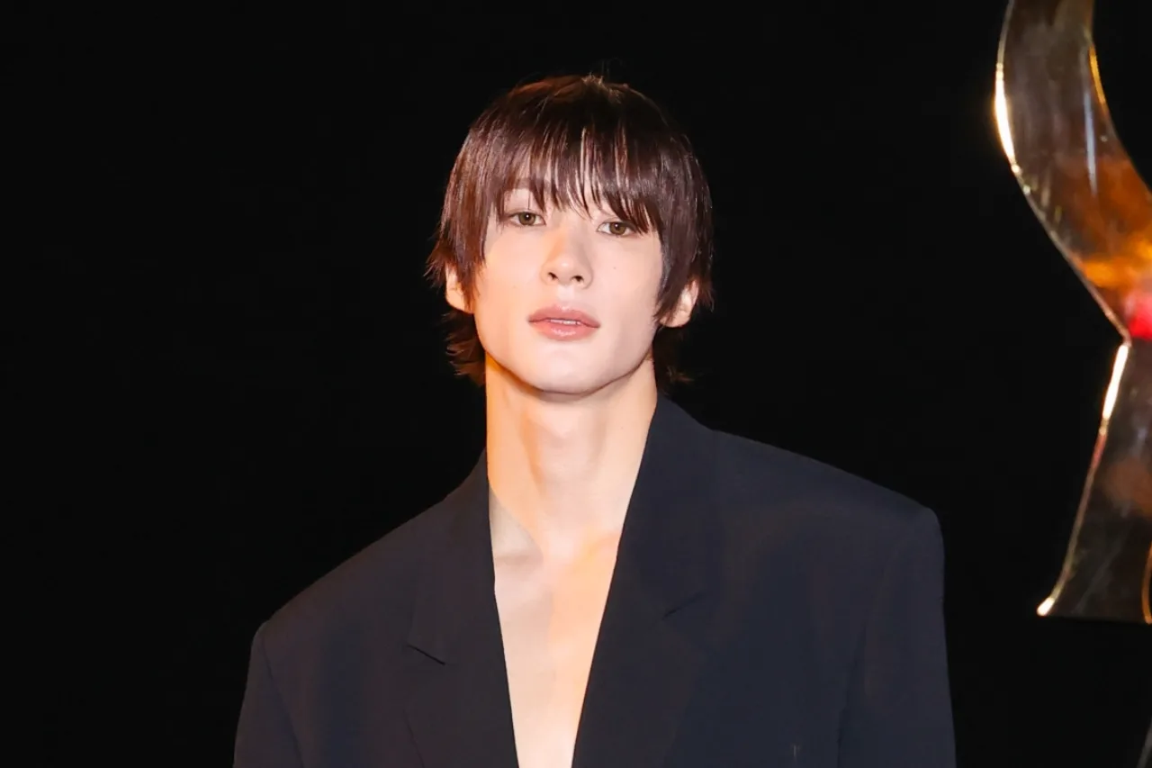 Anton, do RIIZE, desfila em traje Saint Laurent no show Spring/Summer 2027, com o logo da casa ao fundo