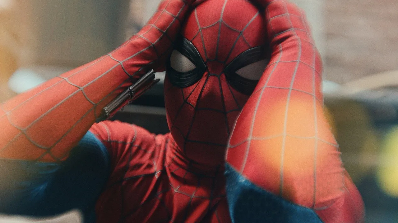 Modelo em traje de Spider‑Man fazendo flexão em parque de Amsterdã, com bandeira da Sony ao fundo