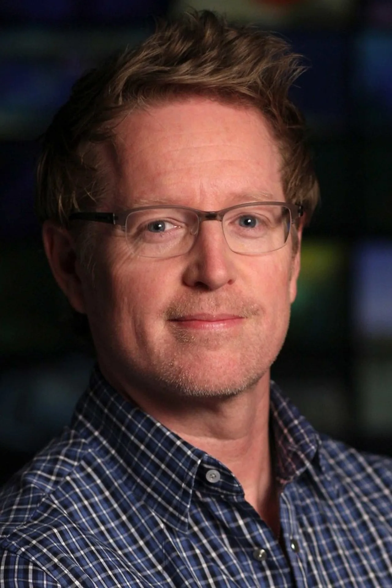 Andrew Stanton segurando um boneco do Woody ao lado de um laptop aberto com roteiro de Toy Story 6