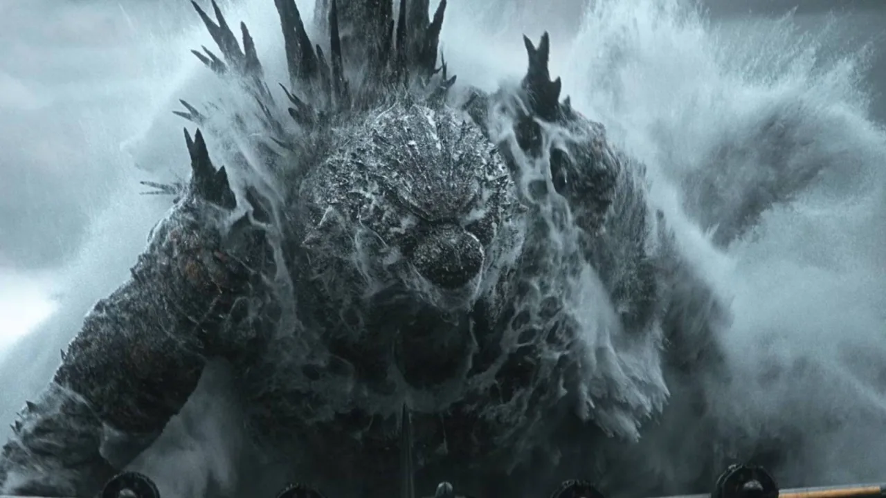 Um homem fazendo agachamento segurando um haltere ao lado de uma caixa de colecionáveis Godzilla