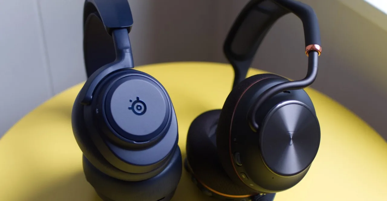 Headset gamer premium sobre uma mesa organizada ao lado de um teclado mecânico e monitor com luzes RGB neon
