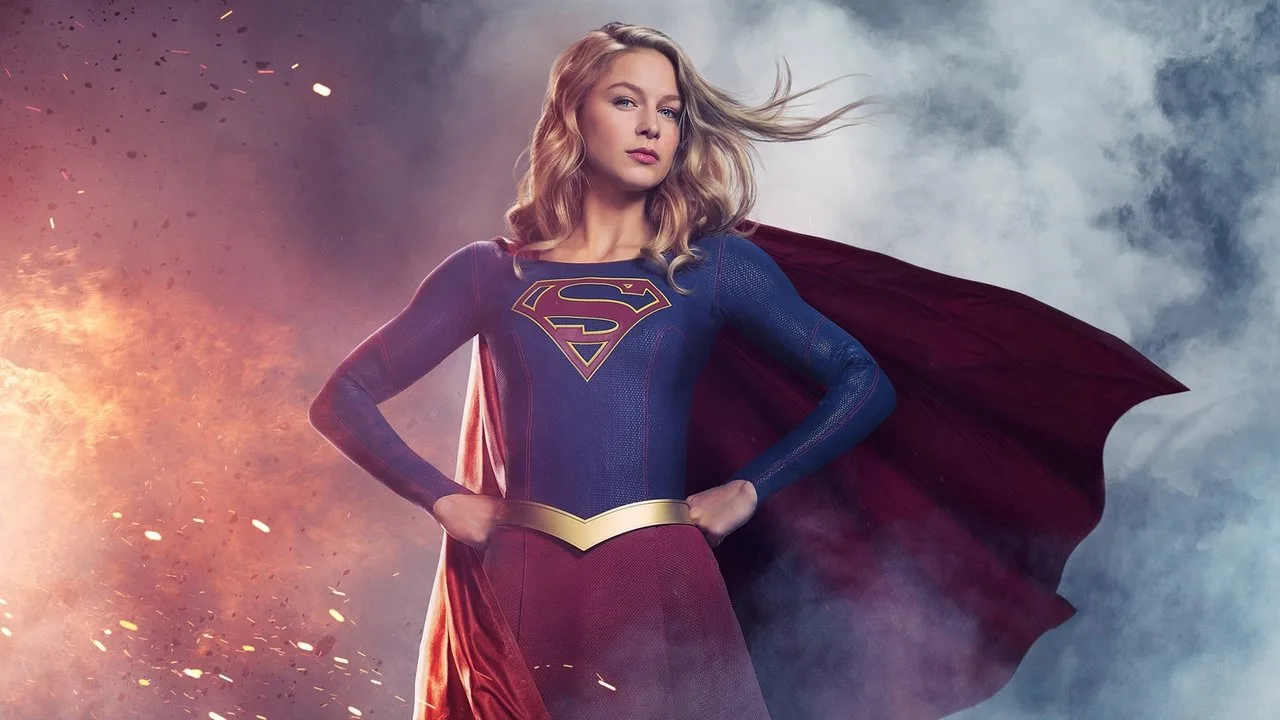 Supergirl em pose heroica sobre fundo vibrante, segurando uma edição clássica de quadrinhos com arte de Tom Grummett