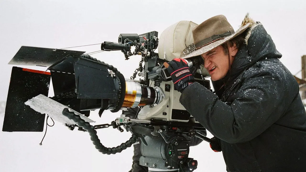 Atleta segurando um clapperboard como peso, fazendo agachamento ao lado de um machado de brinquedo