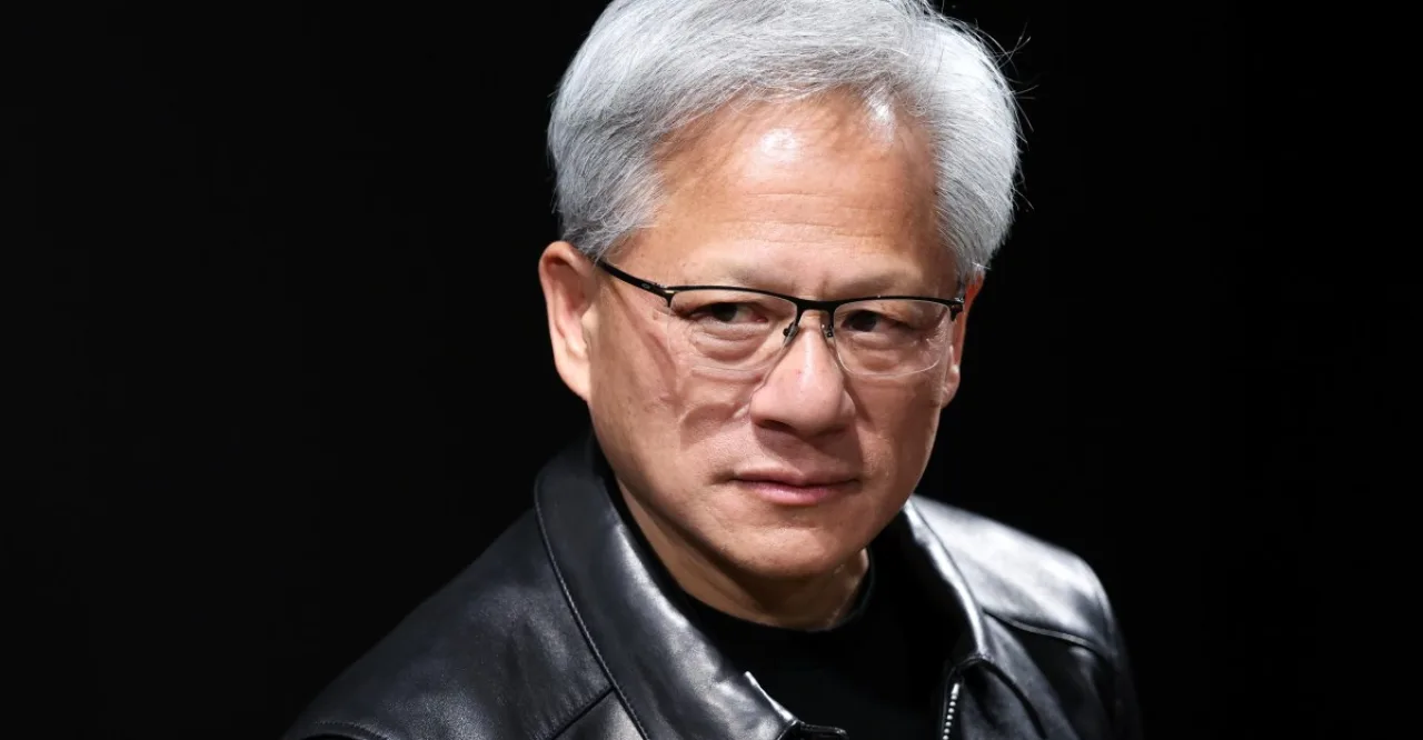 Jensen Huang, CEO da Nvidia, em estúdio, ao fundo o logotipo da empresa e servidores de data center