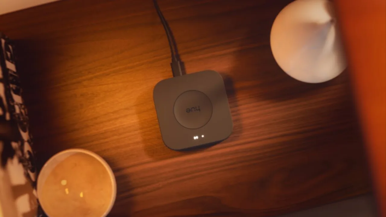 Pessoa fazendo yoga em sala com lâmpadas Philips Hue acesas enquanto olha o smartphone
