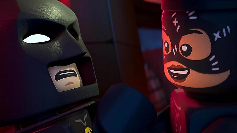 Jovem faz agachamento segurando o Switch 2 com LEGO Batman, garrafa d’água e toalha ao lado