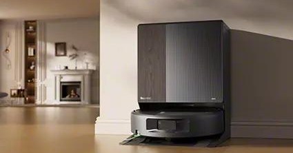 Jovem em roupa de treino faz alongamento no tapete enquanto o Roomba premium o aspira ao fundo