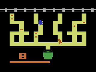 Controle de PS5 sobre mesa ao lado de maçã verde e garrafa d'água, com personagens de Sesame Street na tela