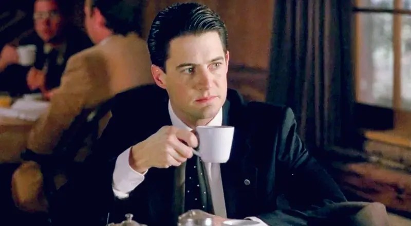 Cartão de Twin Peaks assinado por David Lynch e Kyle MacLachlan, em destaque sobre fundo escuro com o logo da série